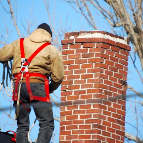 man on roof working on chimney