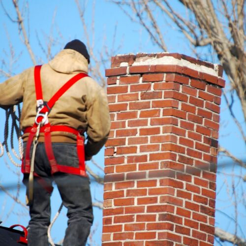 chimney repairman on roof