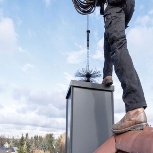 A professional chimney sweep inspecting a clean chimney flue.