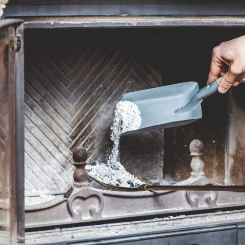 man cleaning ash from fireplace